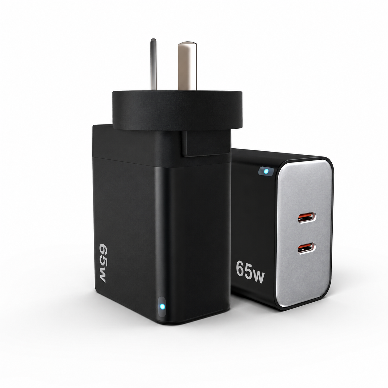 A 65W dual-port USB-C wall charger shown from two angles: one view showing the black plug body with silver prongs and '65W' text, and another showing the black and silver face with two USB-C ports and small blue indicator lights.