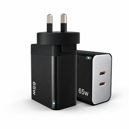 A 65W UK wall charger adapter shown from two angles: one showing the black UK two-pin plug and the other showing the front with two USB-C ports on a silver faceplate, both on a white background.