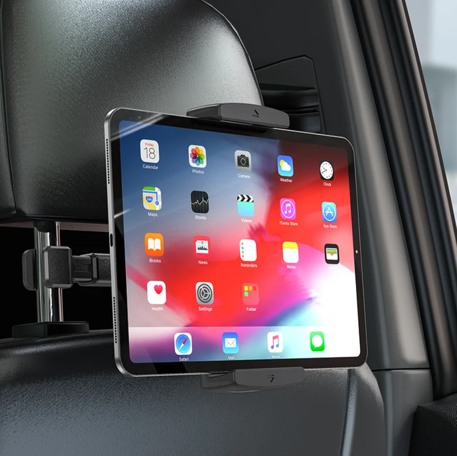 A tablet mounted on a car headrest using a black adjustable clip-on holder, shown inside a vehicle with the dashboard and window visible.