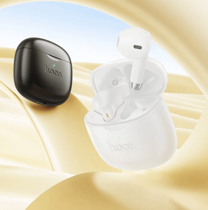 White wireless earbuds with black charging case on a beige background