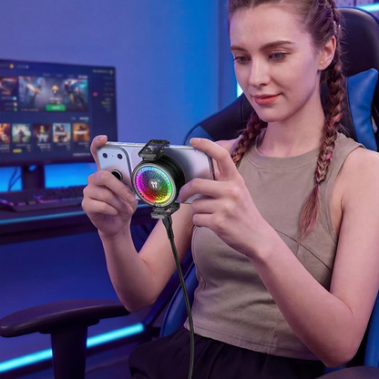 A woman in a gaming chair holding a smartphone with a circular RGB light accessory attached, in a blue-lit gaming room.