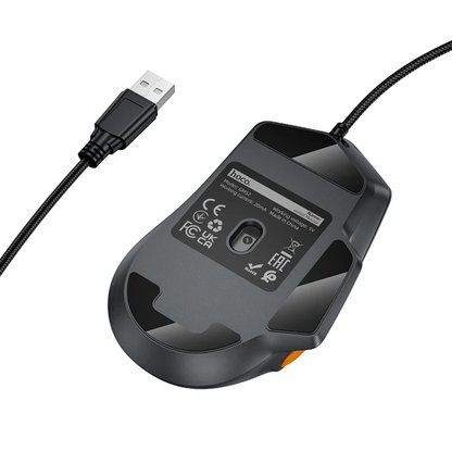 A black wired computer mouse shown from the underside, with a USB connector visible on the left and a small orange accent on the right side. The underside has printed specifications and regulatory symbols on a white background.