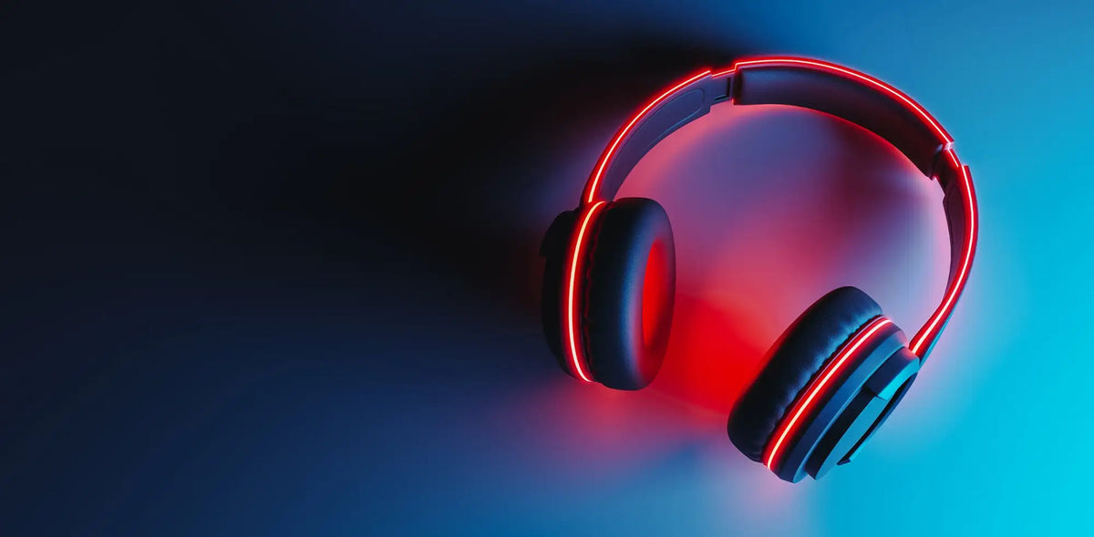 Over-ear wireless headphones with glowing red LED accents, shown floating against a dark blue and cyan gradient background.
