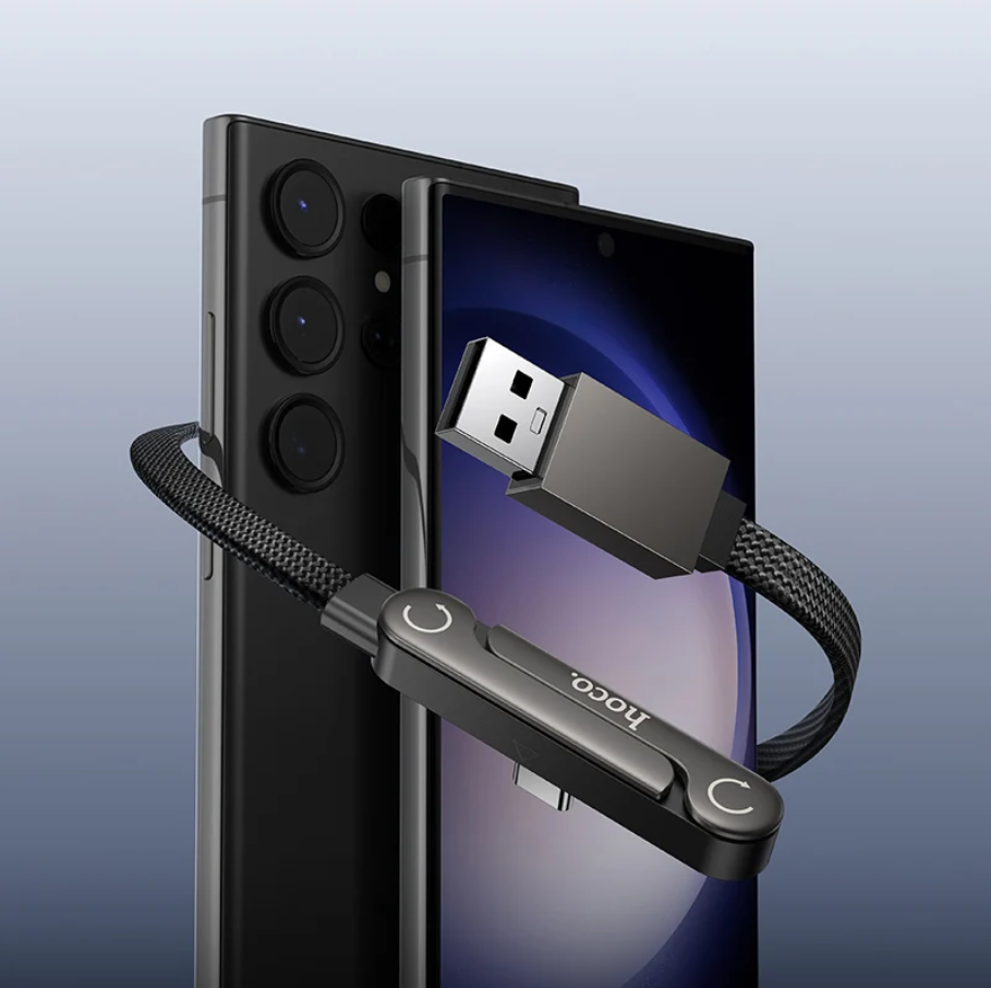 A black USB dongle with a braided cable and a USB-A connector, shown attached to a smartphone on a clean light blue gradient background. The dongle has the brand name 'booco' printed on it.