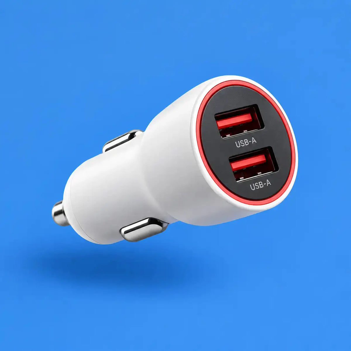 A white car cigarette lighter charger with two USB-A ports, featuring a black face ring with red accents, shown floating against a solid blue background.