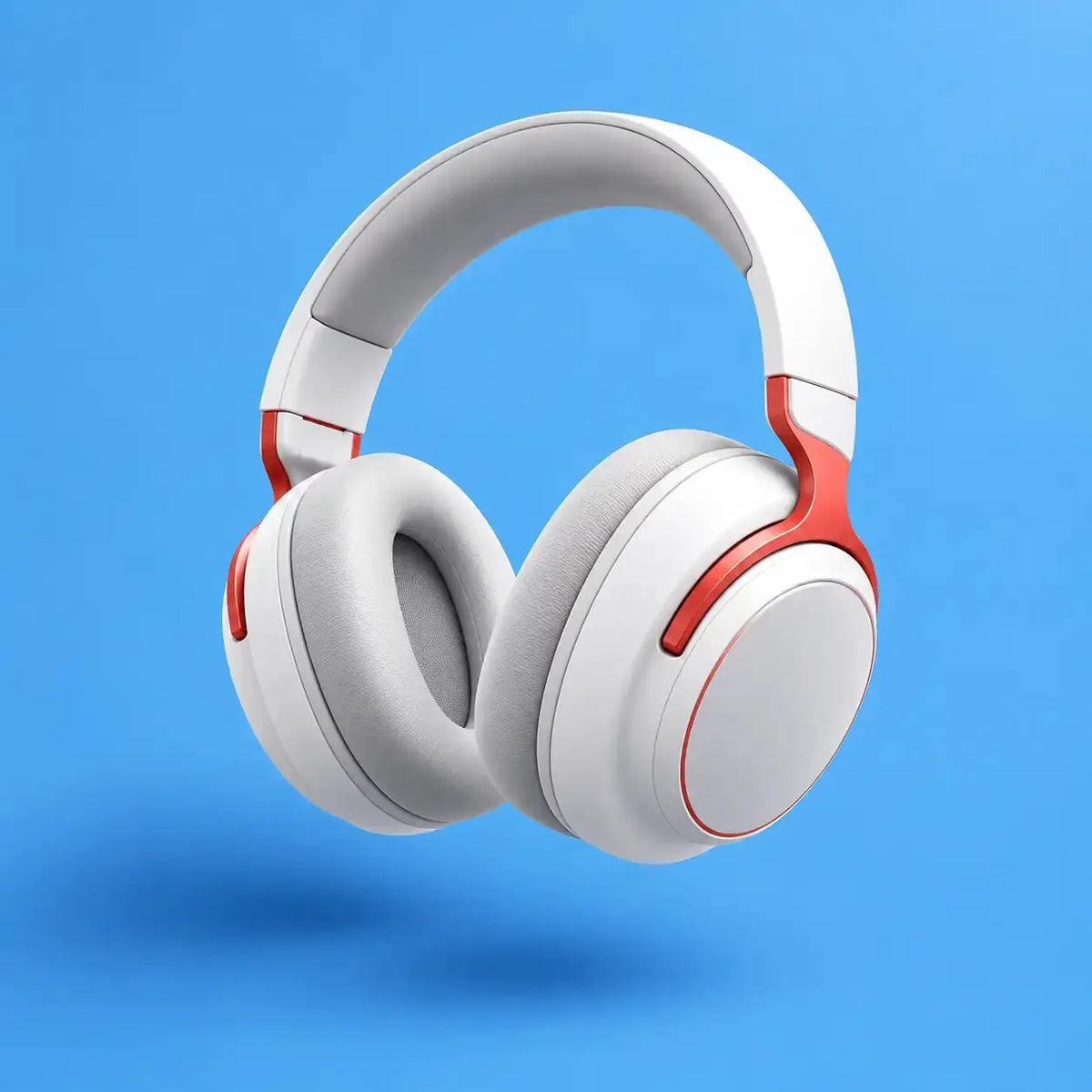 White over-ear headphones with red accents, shown floating against a solid blue background.